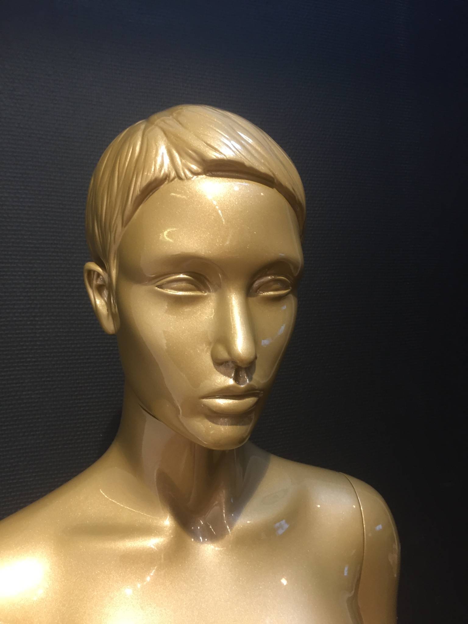 Gold female mannequins with different faces and positions.