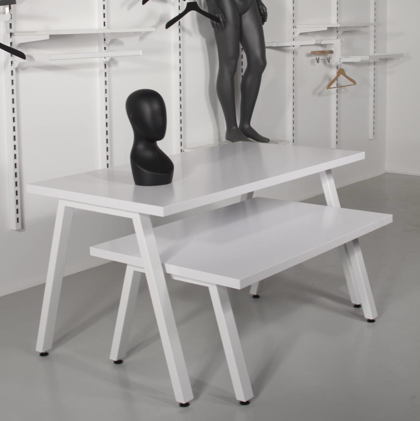 salgsborde i hvid med skråtstillede metalben.