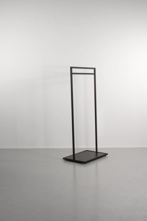 black clothes rack with black base plate. Exhibition stand, the clothing store or at home